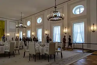 Großer Saal mit Tischen für ein Dîner