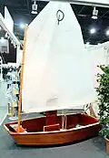 Optimist mit traditionellem Sperrholzrumpf ausgestellt auf einer Messe