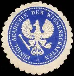 eine Siegelmarke, zentral abgebildet ein Adler, um den herum im Kreis in Großbuchstaben die Aufschrift „Königl. Akademie der Wissenschaften“ zu lesen ist
