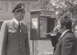 Siegfried Steiger telefoniert mit einem aufgestellten Notruftelefon in Anwesenheit eines Polizisten, 1971