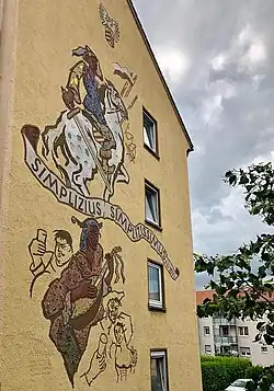 Simplicius Simplicissimus Darstellung als Sagraffito mit bunten Glas gehöht an einem Wohnhaus in der Nordstraße in Hanau.