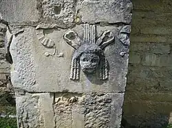 Römische Theatermaske einer Spolie an der Außenwand der Südseite