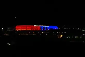Die Galerie (Sektor G) bei Nacht beleuchtet in den Farben des FC Basel