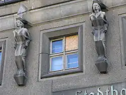 Zwei von vier gleichen Wasserspringer-Darstellungen über dem Portal des Stadtbades Lichtenberg in Berlin