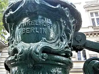 Firmeneintrag am Spiegel (links vom Schwengel)