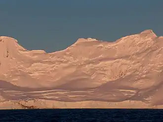 Blick von der Bransfieldstraße auf den Strandscha-Gletscher (im Hintergrund: Spartacus Peak (links), Yavorov Peak (Mitte), Elena Peak (rechts))