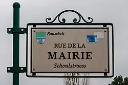 Zweisprachiges Schild in Bauschleiden: Schoulstrooss / Rue de la Mairie (franz. für Rathausstraße)