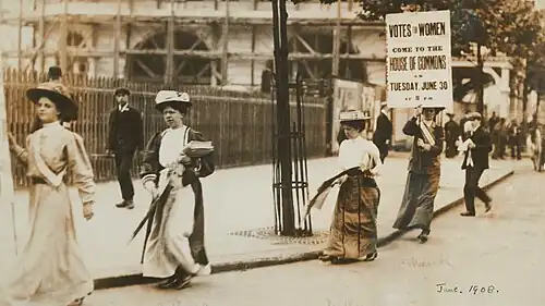 Demonstration in London, 30. Juni 1908; von links: Dorothy Hartopp Radcliffe, Dora Beedham (mit Flugblättern), Hilda Dallas und Charlotte Marsh (mit Plakat)