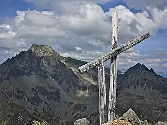 Gipfelkreuz mit Piz Güglia im Hintergrund