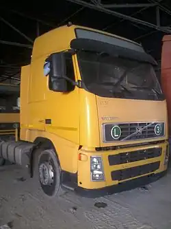 Photo einer abgestellten Sattelzugmaschine, an der vorne eine Plakette mit der Aufschrift „3“ für „EURO3 sicheres“ Fahrzeug und eine Tafel mit dem Buchstaben&nbsp;L angebracht ist.