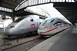 Zwei Züge stehen nebeneinander in einem Bahnhof