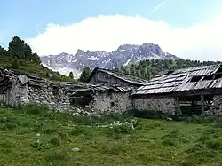 Zerfallende Hütten auf der Alp Tamangur Dadora. Im Hintergrund links der Lorenziberg, rechts der Piz Murtera.