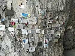 Die mit Gedenktafeln bedeckten Felswände im Innenraum der Kapelle