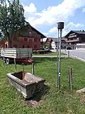 Teilsäule für einen Abhnehmer und die nebenstehende Viehtränke in Langenegg, Österreich