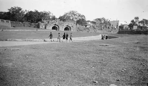 Group of Indian natives passing by an old fortress in Delhi, India