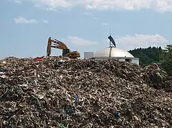 Das Dach des vom Tsunami beschädigten Whale & Marine Science Museum hinter einem Trümmerhügel[10] (Foto: 17. Juli 2011)