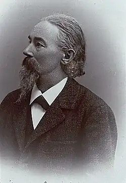 Theodor Gartner mit längerem Bart, in dunklem Anzug und mit Blick nach links