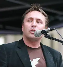 Foto eines Mannes, der in ein Mikrofon spricht