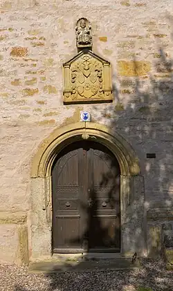 Seiteneingang der Kirche mit Wappen