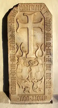 Grabstein des Andreas von Graben zu Sommeregg mit den Wappen der Von Graben (links) und Barbara (sowie Jörg) von Hallegg (rechts) an der Außenmauer der Kirche in Treffling