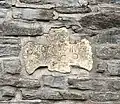 Fragment eines Grabkreuzes (ca. 18. Jh.) in der Friedhofsmauer