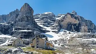 Die Hütten im oberen Vallesinella mit dem Stock der Cima Brenta im Hintergrund. Links das S.A.T.-Haus, rechts die von der Sektion Berlin errichtete Hütte