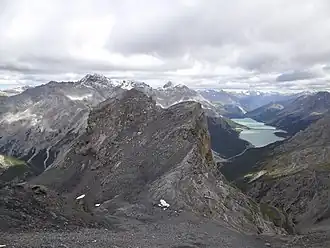 Die höchsten Gipfel der Umbrailgruppe (schneebedeckt, von links nach rechts: Piz Murtaröl, Piz Magliavachas und Piz Tea Fondada) über dem Valle di Fraéle.