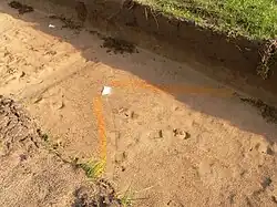Gebäudeecke eines steinzeitlichen Gebäudes, Wandverlauf parallel dazu farblich markiert