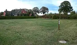 Innerhalb der Wohnbebauung ein noch unbebauter Bereich, in den sich das Urnengräberfeld erstreckte. In Höhe der Bäume verläuft die B 215