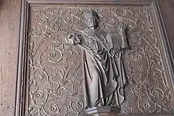 Figur mit Kirchenmodell