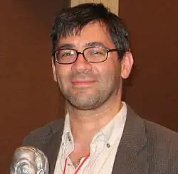 Portraitfoto eines Mannes vor einem Mikrophon