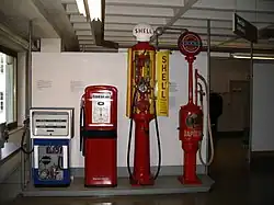 Historische Zapfsäulen im Deutschen Museum (rechts eine „Eiserne Jungfrau“)