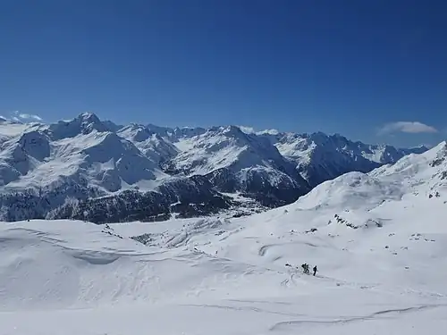 Blick Richtung Süden auf den westlichen Teil der Bernina-Alpen (Piz da la Margna, Cima di Rosso, Cima di Castello, Piz Cengalo, Piz Badile) und Maloja im Tal,