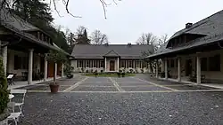 Der Vorhof mit dem ehemaligen Bedienstetengebäude (rechts) sowie den früheren Pferdeställen und Garagen (links).