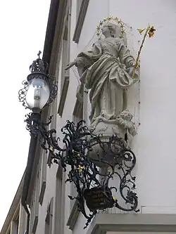 Schmiedeeiserner Leuchterarm (um 1745) unter einer Hausmadonna (Blasiusgasse 9)