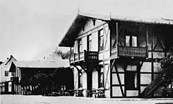 Schwarzweiß-Fotografie von einem Häuserkomplex in alpin anmutenden Stil