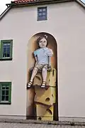 Malerei an der Hauswand beim Kindergarten („Dreikäsehoch“)