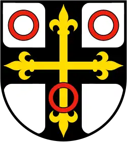 durchgehendes schwarzes Deutschordenskreuz (Heroldsbild), belegt mit einem goldenen Lilienkreuz (gemeine Figur)