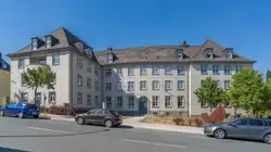 Beiges Gebäude im Sommer mit Straße im Vordergrund