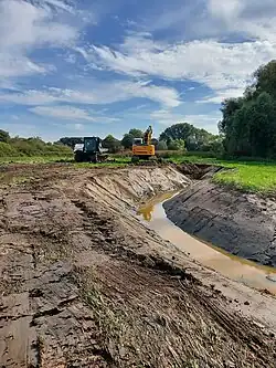 Bagger beim Ausheben eines Priels