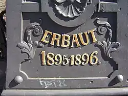 Vergoldete schmiedeeiserne Schriftzüge (Name und Bauzeit der Brücke)