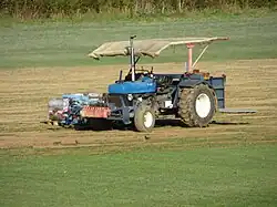 Eine Rollrasen-Erntemaschine schält standardisierte Grassoden