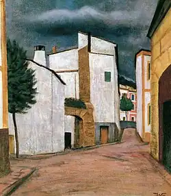 In einer südlichen Landschaft führt eine rötliche Straße zwischen weißen und gelben Häusern hindurch. Im Himmel ballt sich eine dunkle Wolke.