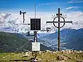 Wetterstation auf den Grundmauern des 1959 abgebrannten Sattelberghauses, dahinter das Gipfelkreuz