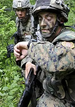 Soldat des 1.&nbsp;Infanterie-(Garde-)Regiments OS&nbsp;BiH (Traditionsregiment HVO) mit seinem Partner von der US-Armee während eines Manövers auf dem Truppenübungsplatz „Eugen Kvaternik“ (2012) und Ärmelabzeichen der Einheit.