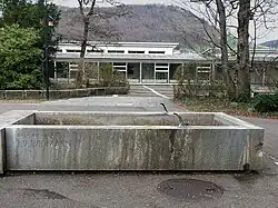 Sekundarschule Liestal. Widmann-Brunnen, Relief «Der Heilige und die Tiere». Eingeweiht am 6. Nov. 1961. Das Relief ist heute nicht mehr am Brunnen zu sehen.