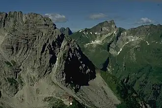 Schneck (Gipfel rechts der Bildmitte) mit seiner Ostwand von Nordosten. Der Berg am linken Bildrand ist der Wiedemerkopf, dazwischen die Höfats im Hintergrund. Am rechten Bildrand die drei Gipfel des Rotkopf.