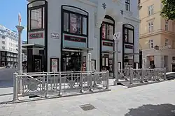 Silberne Sonnenblumengeländer flankieren die Stiegen der öffentlichen Bedürfnisanstalt in der Irisgasse