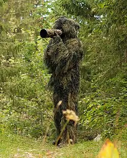 Tierfotograf trägt einen ghillie suit
