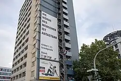An einem Hochhaus wurde ein Plakat montiert.